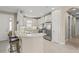 Modern kitchen boasting white cabinets, stainless steel appliances, and a breakfast bar with stylish seating at 5556 Cantucci St, Nokomis, FL 34275