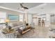 Inviting living room featuring modern furniture, a ceiling fan, and an open layout leading to the kitchen at 5556 Cantucci St, Nokomis, FL 34275
