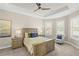 Bright main bedroom featuring trey ceiling, ceiling fan, neutral colors, and plantation shutters at 5556 Cantucci St, Nokomis, FL 34275