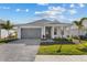 Charming single-story home with a gray driveway, attached garage, and landscaped front yard under a sunny sky at 8071 Slipway Dr, Sarasota, FL 34240