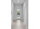 A bright and inviting hallway featuring tile flooring and a door with glass panels that provides natural light at 8071 Slipway Dr, Sarasota, FL 34240