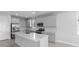 Modern kitchen featuring gray cabinets, stainless steel appliances, and an island with a sink and white countertop at 8071 Slipway Dr, Sarasota, FL 34240