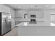 Modern kitchen featuring sleek gray cabinets, stainless steel appliances, and a large kitchen island with a sink at 8071 Slipway Dr, Sarasota, FL 34240