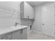 Laundry room with modern cabinets, sink, countertop, and a door to the outside at 8071 Slipway Dr, Sarasota, FL 34240