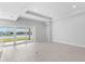 An airy room with tile flooring, recessed lighting, and large sliding glass doors with a view of the lake at 8071 Slipway Dr, Sarasota, FL 34240