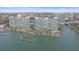Aerial view of condo buildings along the water, with boat docks and lush landscaping at 888 Blvd Of The Arts # 1008, Sarasota, FL 34236