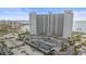 Wide aerial view of a condo building, tennis courts, and waterfront access at 888 Blvd Of The Arts # 1008, Sarasota, FL 34236