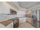 Well-lit kitchen showcasing stainless steel appliances, light wood cabinets, and granite countertops at 888 Blvd Of The Arts # 1008, Sarasota, FL 34236