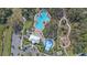 Overhead view shows a sparkling community pool, splashpad, and playground with walking paths at 10451 Ladybug Cv, Parrish, FL 34219
