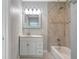 Well-lit bathroom with a tiled shower, bathtub, and stylish vanity at 115 24Th W St, Bradenton, FL 34205