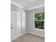 Cozy bedroom featuring a window with a view of the lush greenery outside, and a white door at 115 24Th W St, Bradenton, FL 34205