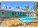 Backyard pool area with a wooden deck and tropical landscaping, ideal for enjoying the outdoors at 115 24Th W St, Bradenton, FL 34205