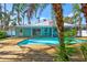 Inviting pool area with a wooden deck and tropical landscaping, perfect for relaxation and entertaining at 115 24Th W St, Bradenton, FL 34205