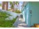 The side yard features a stone pathway leading to a fenced-in yard, lush greenery, and the side of the house at 115 24Th W St, Bradenton, FL 34205