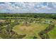 An aerial view of a beautiful community green space featuring a playground, walking paths, and lush landscaping at 13232 Saw Palm Creek Trl, Bradenton, FL 34211
