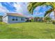 View of well maintained lawn, palm trees, and private backyard with lake access on a sunny day at 13232 Saw Palm Creek Trl, Bradenton, FL 34211