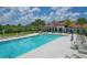 Large community pool surrounded by lounge chairs, umbrellas, and meticulously maintained grounds at 13232 Saw Palm Creek Trl, Bradenton, FL 34211