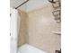 Shower and tub combo featuring basket shelves, bronze fixtures, and tan tiling at 13232 Saw Palm Creek Trl, Bradenton, FL 34211