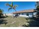 Expansive backyard with a lush lawn, mature landscaping, and a covered patio area for outdoor entertaining at 13575 Martha Ave, Port Charlotte, FL 33981