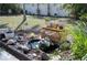 Beautiful backyard fish pond surrounded by a rock garden, lush plants, and greenery at 13575 Martha Ave, Port Charlotte, FL 33981