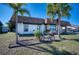 Charming single-story home with well-manicured lawn, mature palm trees, and a quaint bicycle accent at 13575 Martha Ave, Port Charlotte, FL 33981