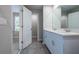 Well-lit bathroom with double sink vanity, ceramic tile, and an open doorway at 17136 Blowfish Dr, Nokomis, FL 34275