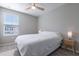 Bright bedroom with a ceiling fan, a comfortable bed, and ample natural light from the window at 17136 Blowfish Dr, Nokomis, FL 34275
