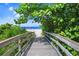 Beautiful boardwalk leading to a pristine sandy beach, framed by lush, green foliage at 17136 Blowfish Dr, Nokomis, FL 34275