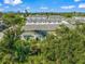 View of a townhouse in a multi-unit complex, showcasing its green lawn and back patio at 17136 Blowfish Dr, Nokomis, FL 34275