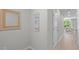 Bright hallway with neutral walls and floors, adorned with decorative wall art and a view of the dining area at 17136 Blowfish Dr, Nokomis, FL 34275