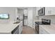 Modern kitchen with stainless steel appliances, white cabinets, and a breakfast bar for seating at 17136 Blowfish Dr, Nokomis, FL 34275