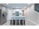 Contemporary kitchen featuring an island with seating, white cabinetry, and stainless steel appliances at 17136 Blowfish Dr, Nokomis, FL 34275