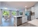 Open concept kitchen and living area with stainless appliances, white cabinets, and a view to the backyard at 17136 Blowfish Dr, Nokomis, FL 34275