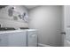 Bright laundry room includes new washer and dryer, shelving, and vinyl floor at 17136 Blowfish Dr, Nokomis, FL 34275