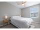 Cozy bedroom with a ceiling fan, neutral walls, carpet, and a bedside table with lamp at 17136 Blowfish Dr, Nokomis, FL 34275