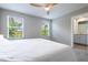 Bright main bedroom features two windows, plush carpet, and bathroom access at 17136 Blowfish Dr, Nokomis, FL 34275