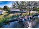 A screened lanai home with a wooden dock on a canal, enhanced by sunny skies and lush trees at 18576 Alphonse Cir, Port Charlotte, FL 33948
