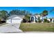 Charming single-story home with a well-manicured lawn, two-car garage, and beautiful landscaping at 18576 Alphonse Cir, Port Charlotte, FL 33948