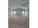 Spacious carpeted living room with a ceiling fan and natural light from two windows at 18576 Alphonse Cir, Port Charlotte, FL 33948