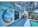 Patio mural featuring a palm tree and beach scene, next to sliding glass doors and pool view at 18576 Alphonse Cir, Port Charlotte, FL 33948