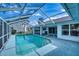 Screened-in pool with clear water, surrounded by a spacious patio and white exterior walls at 18576 Alphonse Cir, Port Charlotte, FL 33948