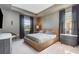 Modern bedroom featuring neutral tones, tray ceiling, large windows, and stylish furniture at 1944 Vang Ln, Sarasota, FL 34240