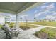 Inviting covered porch with stone pillars and comfortable seating overlooking a picturesque waterside view at 1944 Vang Ln, Sarasota, FL 34240