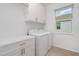 Functional laundry room with white cabinets, modern washer and dryer, and ample countertop space at 1944 Vang Ln, Sarasota, FL 34240