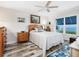 Cozy bedroom featuring a ceiling fan, nautical decor, and a large window with water view at 2424 Placida Rd # C104, Englewood, FL 34224