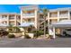 Exterior shot of a charming condo building with lush landscaping and a convenient covered parking area at 2424 Placida Rd # C104, Englewood, FL 34224