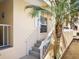 Exterior shot of a charming condo with stairs leading to the entrance, complemented by a palm tree at 2424 Placida Rd # C104, Englewood, FL 34224