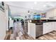 Open concept living room with wood-look floors, modern décor, and lovely water views from the large windows at 2424 Placida Rd # C104, Englewood, FL 34224