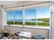 Stunning bay views through large windows in a sunroom area with comfortable seating at 2424 Placida Rd # C104, Englewood, FL 34224