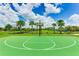 Well-maintained green basketball court featuring white lines and hoops, surrounded by palm trees at 3517 Big Sky Way, Bradenton, FL 34211